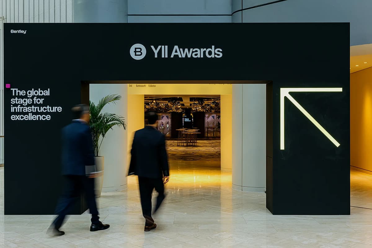 two people walk under arch that says YII Awards