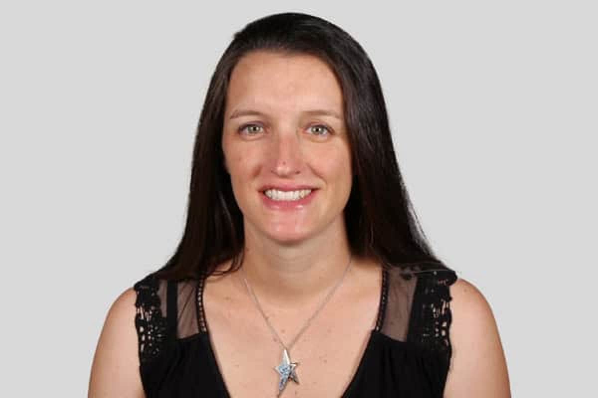 Woman with long dark hair, black shirt, smiling