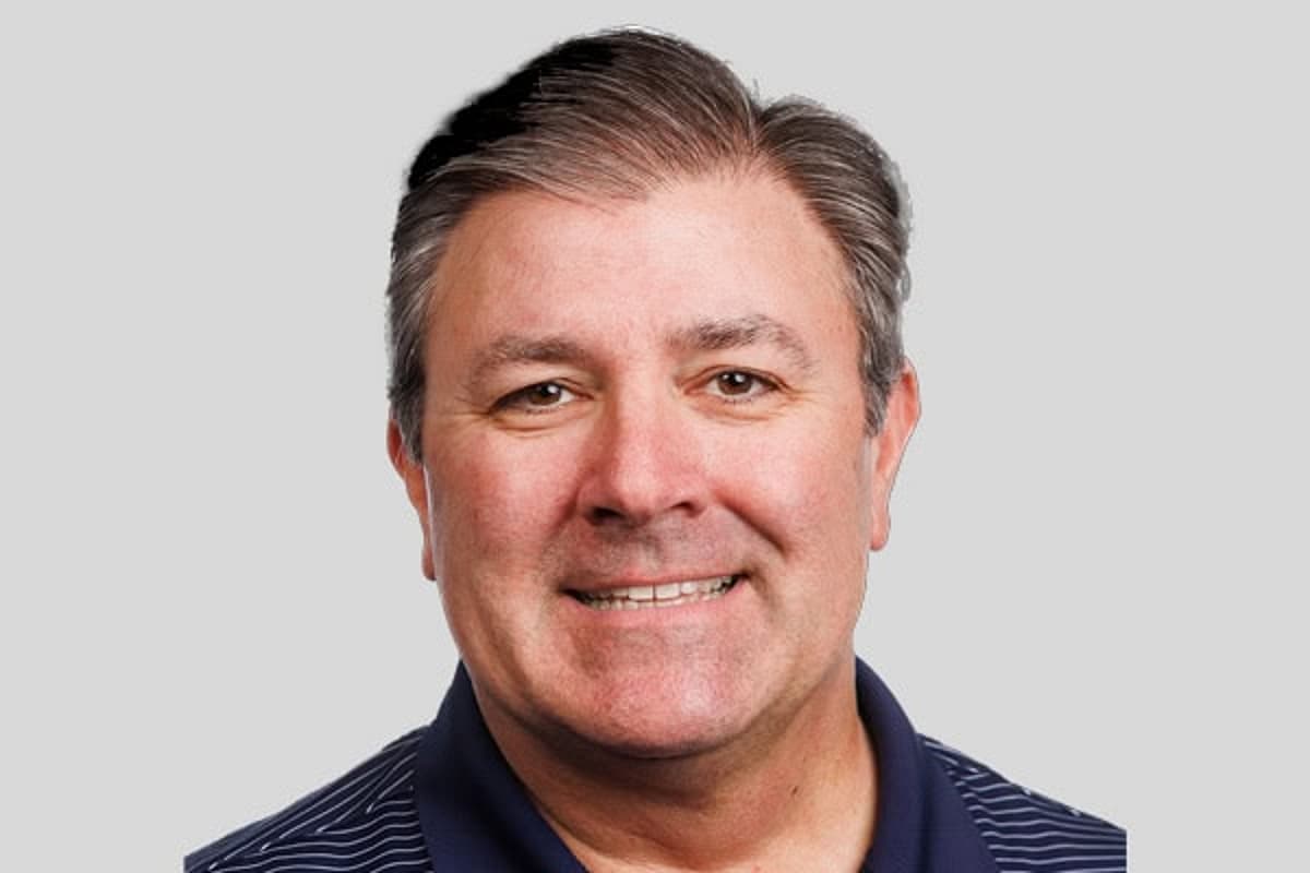 Man with short hair and black shirt, smiling