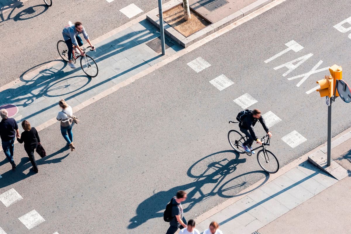 People riding bikes and walking on roadway