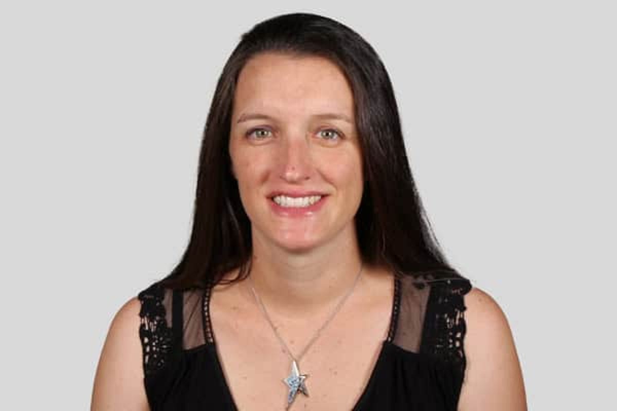 Woman with long dark hair, black shirt, smiling