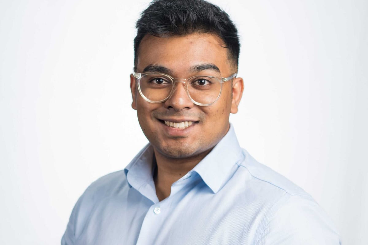 Man in blue shirt and wearing glasses, smiling
