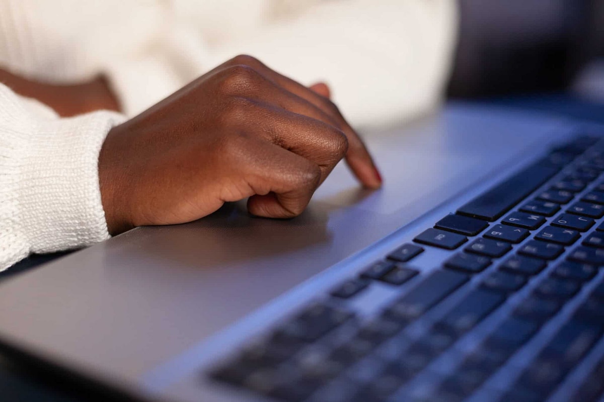 Person's hand touches keyboard on laptop