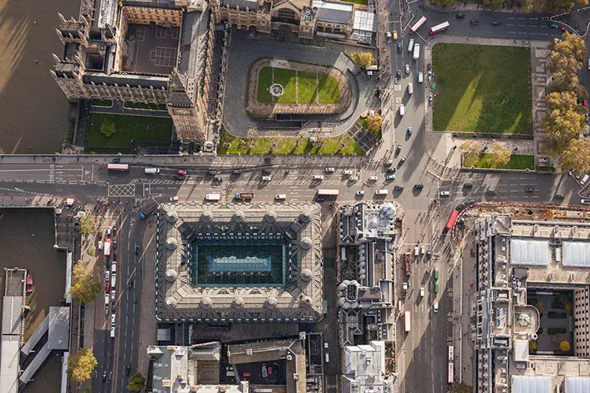 Aerial view of a city with roadways, buildings, natural elements, and vehicles
