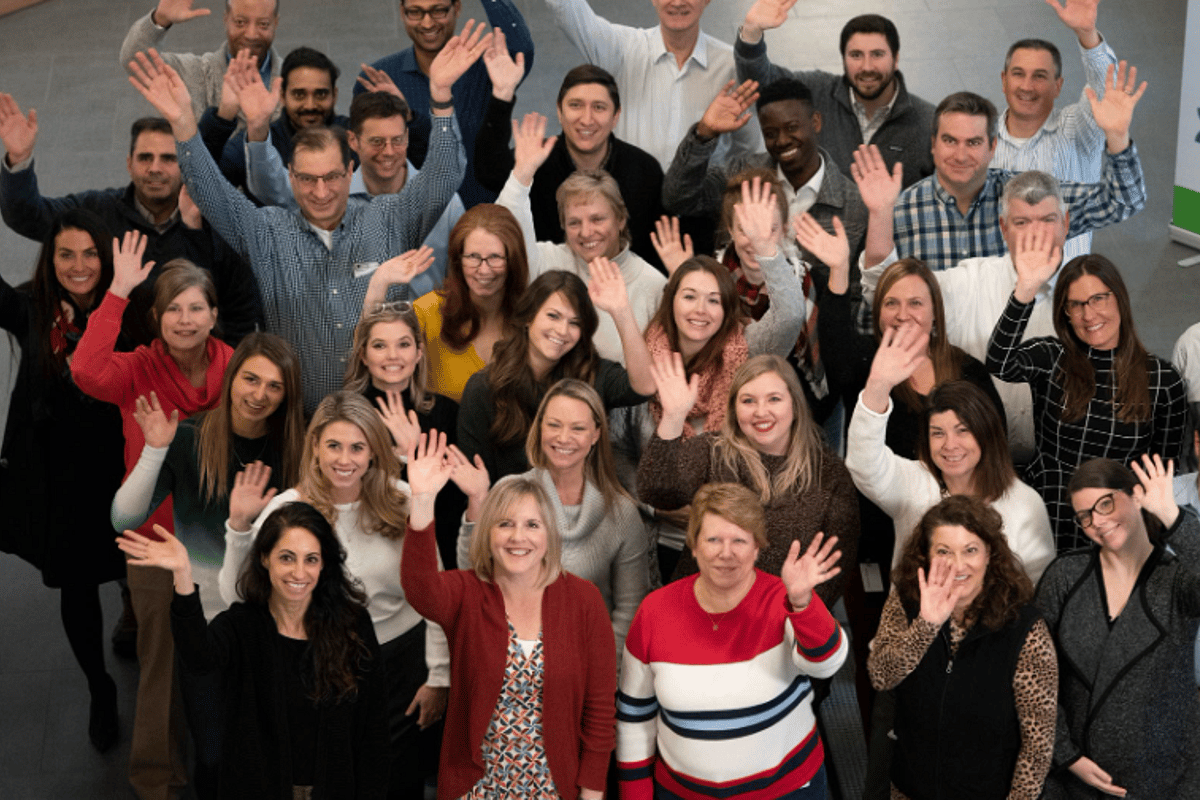 group photo of women and men waving
