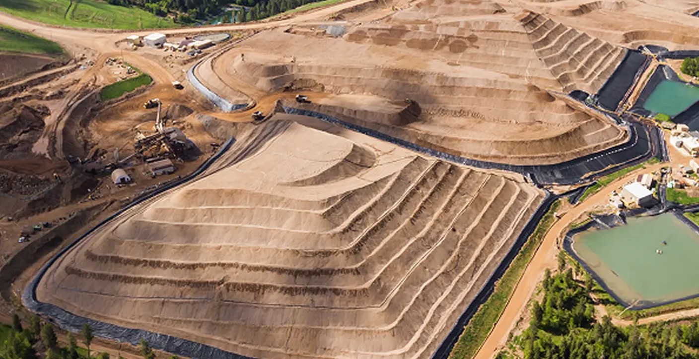 An aerial perspective of terraced mine earthworks and containment basins, illustrating safe waste management, environmental engineering, and sustainable above-ground mining operations.