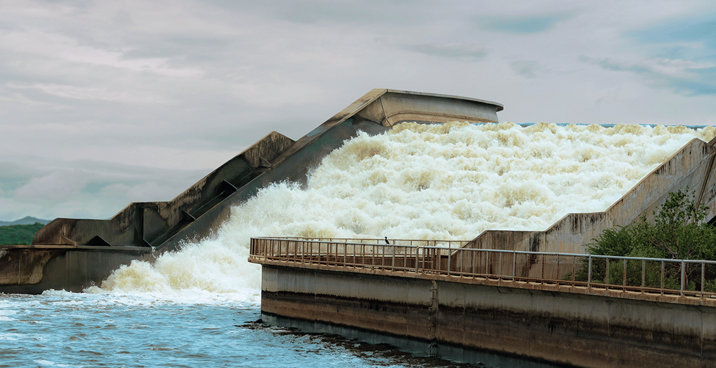 Water rushing down a stepped concrete spillway, illustrating resilient urban stormwater management and flood control infrastructure.