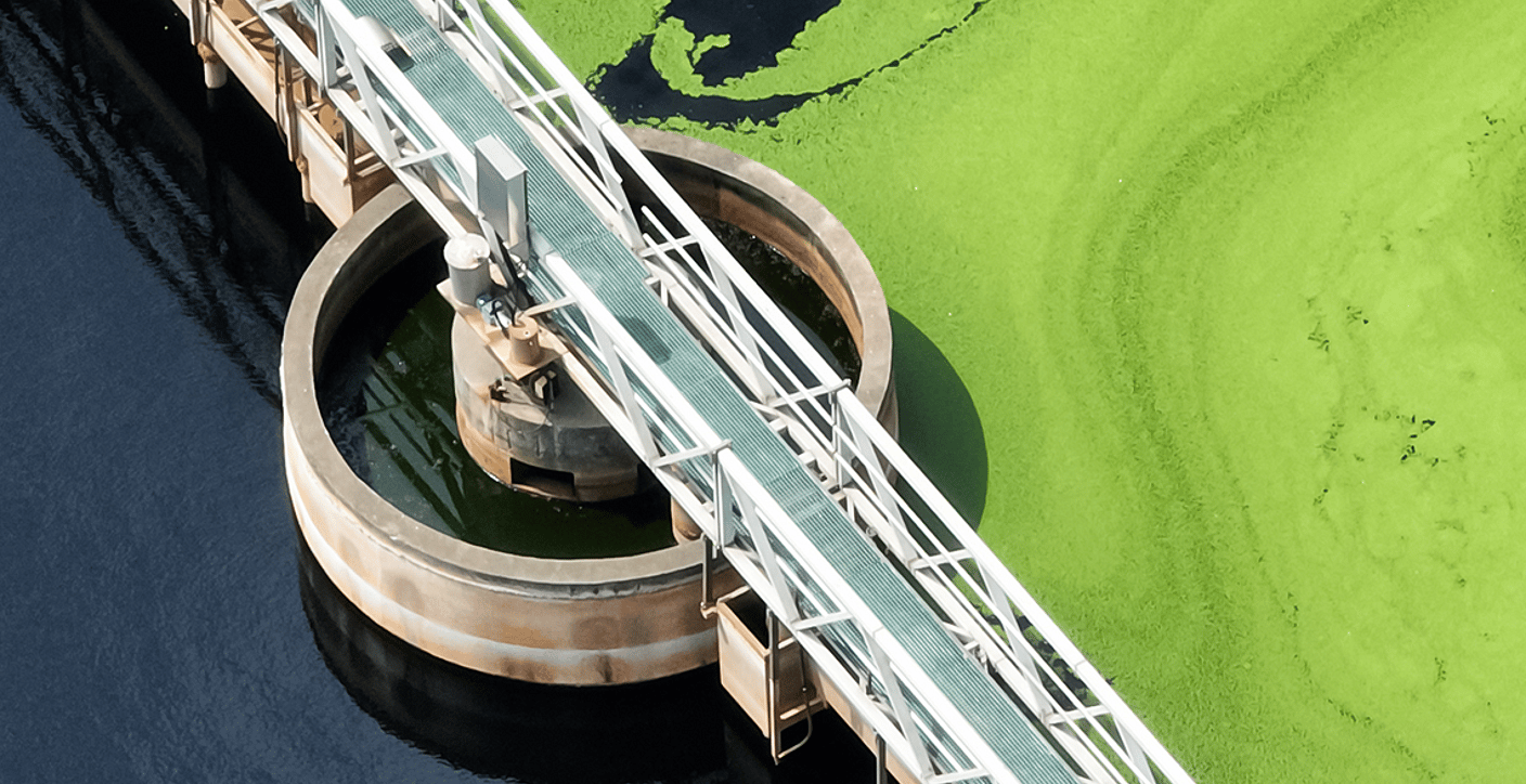 Aerial view of an active wastewater clarifier tank and service bridge, showcasing sustainable municipal sewage treatment and environmental water quality management.