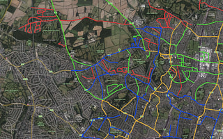 A map showing a road network with color-coded asset data managed in AssetWise Linear Network Management.
