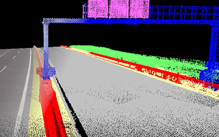 A classified point cloud of a highway in iTwin Capture WorkSuite, with assets like signs and guardrails highlighted in different colors.