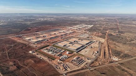 large data center with multiple buildings surrounded by dry land