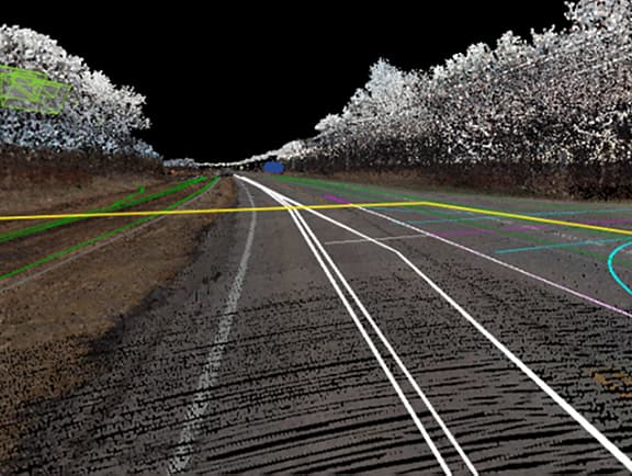 A mobile LiDAR point cloud of a highway corridor in iTwin Capture Reality Management showing vector line extractions for lane markings and road clearances.
