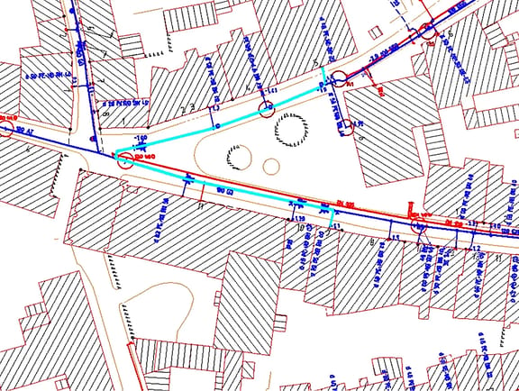 Urban gas and water distribution pipeline network overlay in OpenUtilities sisNET, with detailed 2D municipal street parcels and pipe network connections.