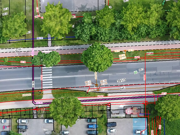 Bentley Descartes software screen showing precise utility engineering vectors, elevation labels, and sewer line drawings overlaid onto a high-resolution aerial raster orthoimage of an urban street.