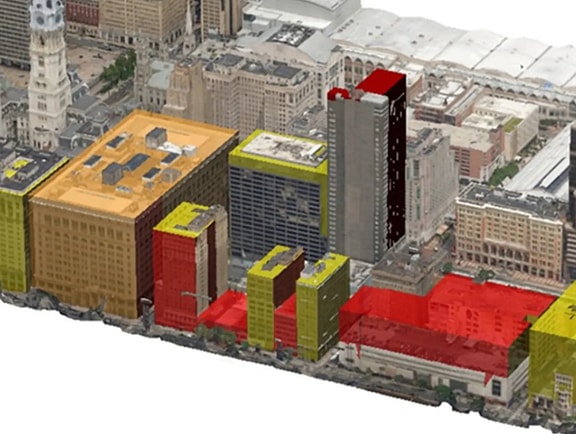 A 3D city model in OpenCities Map visualizing urban infrastructure with color-coded, translucent yellow and red highlights on building footprints for zoning or spatial analysis.