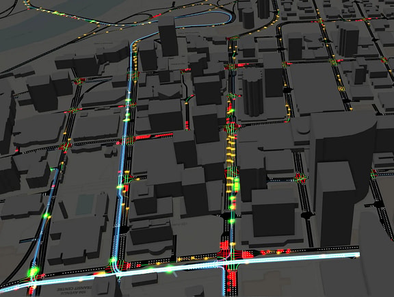 Urban traffic micro-simulation model in OpenPaths, showing multi-lane city streets, building blocks, and vehicle traffic flow colored by speed and congestion.