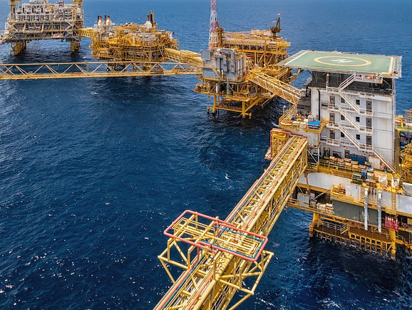 View of connected offshore oil and gas production platforms in the deep blue ocean, highlighting complex multidisciplinary engineering and global energy supply infrastructure.