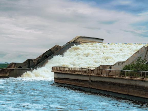 Water rushing down a stepped concrete spillway, illustrating resilient urban stormwater management and flood control infrastructure.
