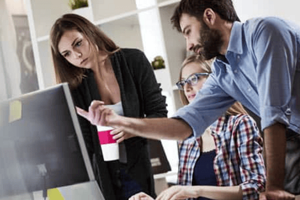 people work at computer while looking at monitor