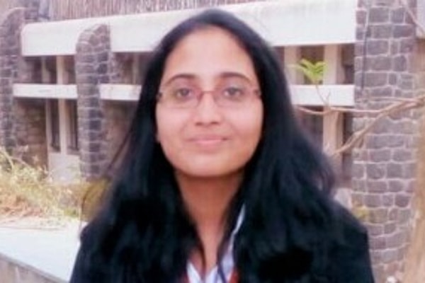 Woman with jacket and glasses, smiling outdoors