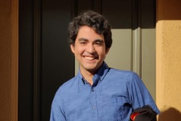 Man in blue shirt, smiling outdoors