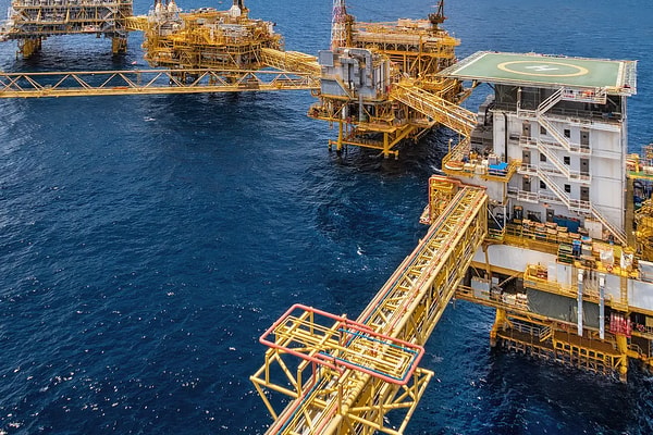 View of connected offshore oil and gas production platforms in the deep blue ocean, highlighting complex multidisciplinary engineering and global energy supply infrastructure
