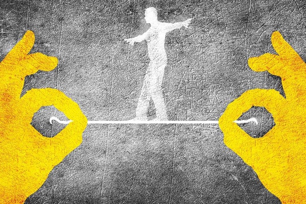 Yellow hands hold white string with figure of a human walking on it