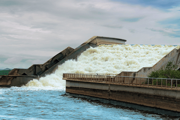 Water rushing down a stepped concrete spillway, illustrating resilient urban stormwater management and flood control infrastructure.