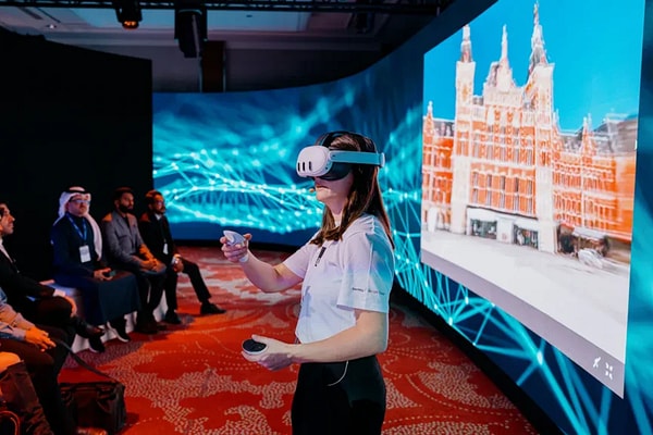 Woman on stage utilizing virtual reality headset at Year in Infrastructure conference