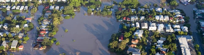 An aerial view of a flooded residential area, representing the kind of devastating aftermath that a forensic analysis team investigates using GeoStudio to simulate the causes of a dam failure.