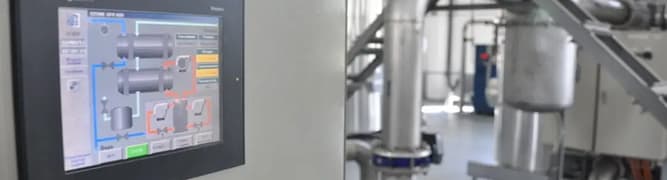 A view of an LLC Aqua water treatment plant, showing the digital control interface alongside the complex piping system that was designed and installed using a 3D digital workflow.