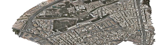 Aerial view of Madinah smart city with dense buildings, roads, and sparse green spaces, highlighting a mix of residential and commercial structures as part of the MDA YII Project.