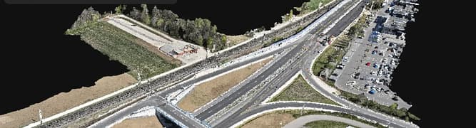 3D rendered aerial view of a highway interchange with multiple roads, parking lots, cars, and a building; menu overlay present in the upper left corner.