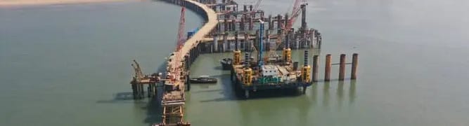 Aerial view of the Mumbai Trans Harbour Sea Link under construction, with cranes and city skyline 