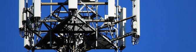 A close-up of a telecommunications tower with multiple antennas.