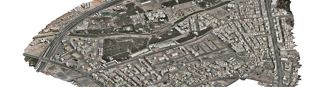 Aerial view of Madinah smart city with dense buildings, roads, and sparse green spaces, highlighting a mix of residential and commercial structures as part of the MDA YII Project.