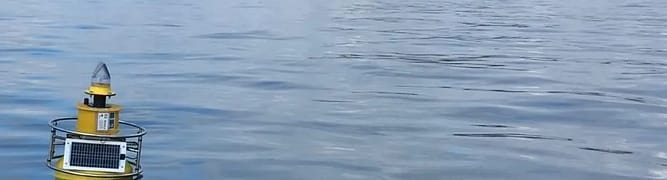 A solar-powered water quality monitoring buoy floating in the sea, one of 16 deployed by the Port of Townsville to provide real-time data for their Channel Upgrade project.