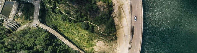 A top-down aerial view of a large concrete arch dam, the type of critical structure that BGC Engineering analyzes for seismic safety and soil-structure interaction using a streamlined PLAXIS and GeoStudio workflow.