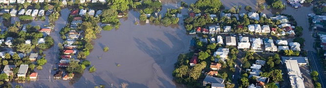 An aerial view of a flooded residential area, representing the kind of devastating aftermath that a forensic analysis team investigates using GeoStudio to simulate the causes of a dam failure.