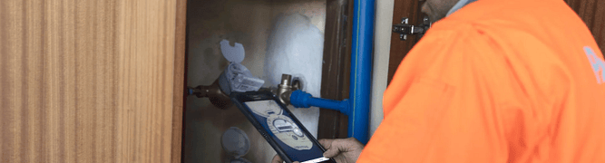An Águas do Porto technician uses a tablet to inspect a water meter.