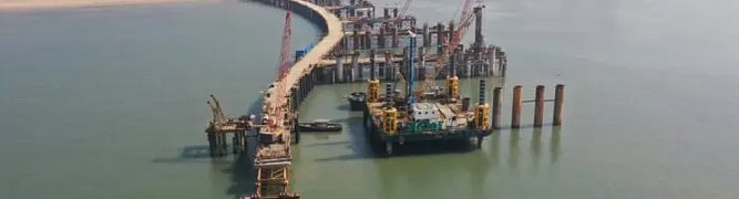 Aerial view of the Mumbai Trans Harbour Sea Link under construction, with cranes and city skyline 