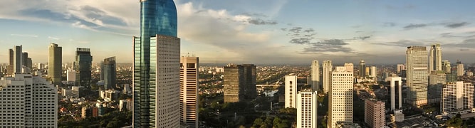 A panoramic view of the dense, modern Jakarta skyline, the complex urban environment where engineers used digital geotechnical modeling for the city's Mass Rapid Transit (MRT) project. 