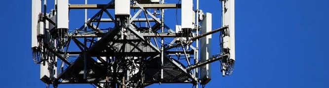 A close-up of a telecommunications tower with multiple antennas.