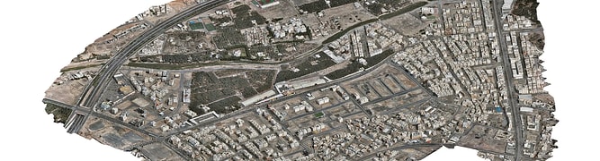 Aerial view of Madinah smart city with dense buildings, roads, and sparse green spaces, highlighting a mix of residential and commercial structures as part of the MDA YII Project.