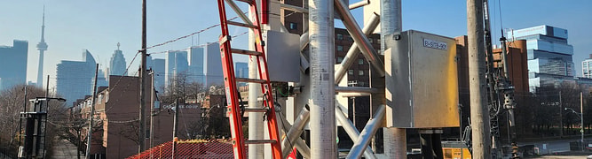 An urban construction site with deep excavation happening right beside the busy Union Station Rail Corridor in Toronto, showing the close proximity that required rigorous structural monitoring.