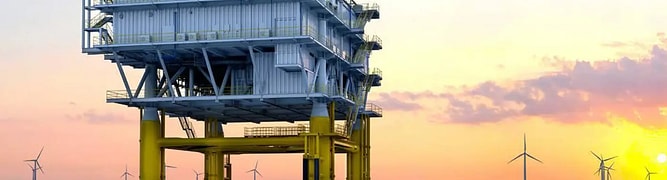 An offshore wind substation at sunset with wind turbines in the distance 