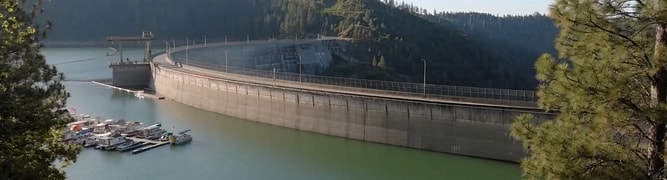 A real-world view of the New Bullards Bar Dam holding back a large reservoir, the site where the Yuba Water Agency implemented an automated remote monitoring system.
