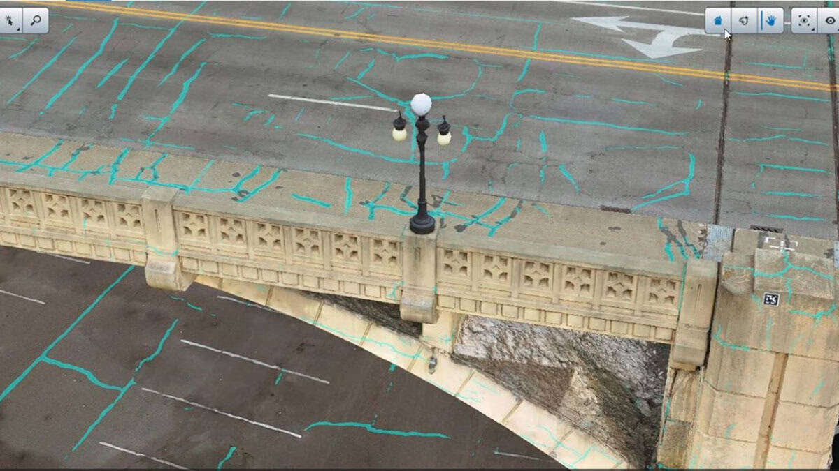 Aerial view of a bridge with a lamp post, road markings, and blue survey lines across the structure&mdash;ideal for Digital Twins modeling and AI analysis in addressing the U.S. Bridge Crisis.