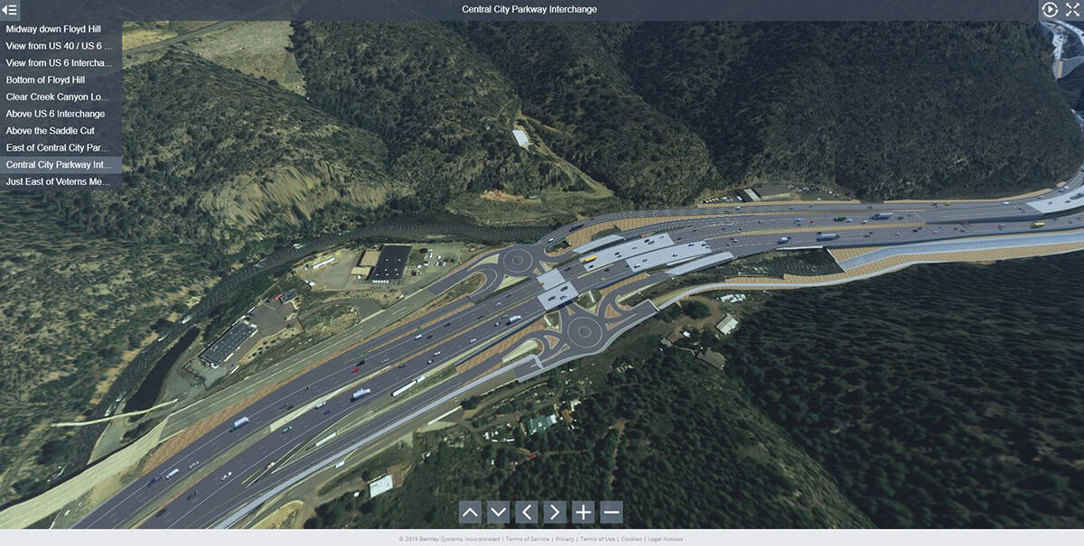 Aerial view of a large highway interchange with multiple lanes, overpasses, and roundabouts surrounded by trees and hills—showcasing tomorrow's roads shaped by advanced roads technology.