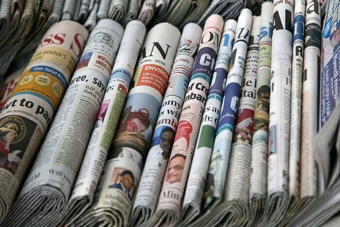 row of paper newspapers stacked fold side up